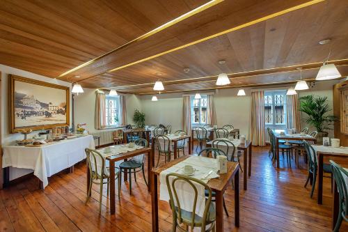 萨梅丹Weisses Kreuz - Crusch Alva的餐厅铺有木地板,配有桌椅