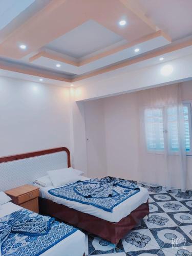 马特鲁港Queen Home Hotel的一间卧室设有两张单人床和天花板
