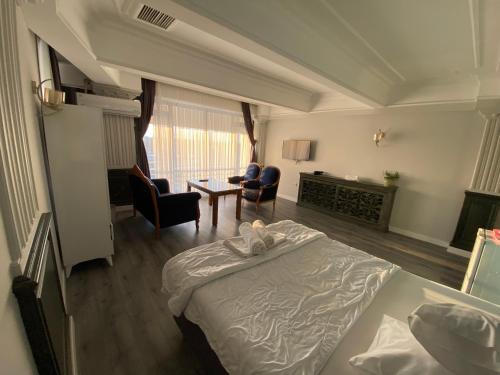 伊斯坦布尔Yalı Houses的一间卧室配有一张床,客厅配有椅子