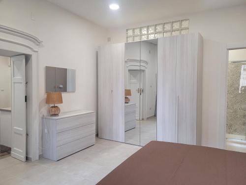 萨萨里Domo Azuni的白色的客房设有镜子和梳妆台