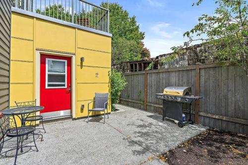西雅图Pacific Trillium Studio, Wallingford 97 Walkscore的黄色的建筑,有红色的门和烤架