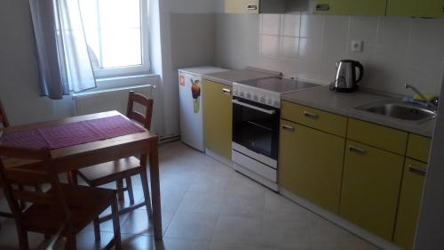 德辛Apartment Zámecká的厨房配有桌子、水槽和炉灶。