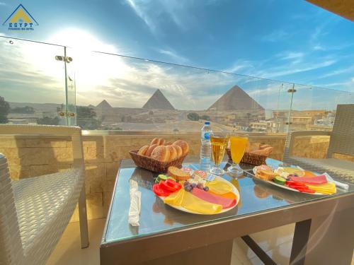 开罗Egypt Pyramids Inn的金字塔阳台的桌子上摆放着食物和饮料