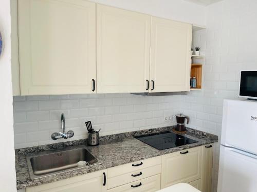 卡拉恩波特Precioso apartamento piscinas Cala en Porter的厨房配有白色橱柜和水槽
