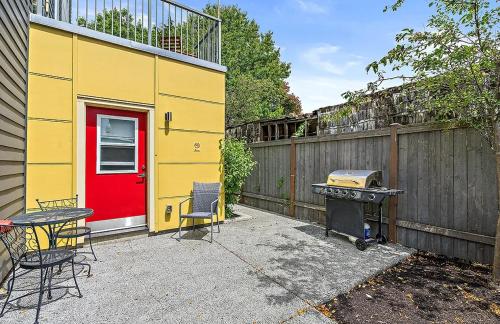 西雅图Garden Dahlia Studio in Wallingford - 97 Walkscore的黄色的建筑,有红色的门和烤架