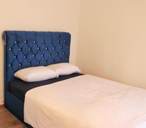 科克Deluxe Dwelling - 15 mins from Cork City/Airport的一张带蓝色床头板和白色枕头的床