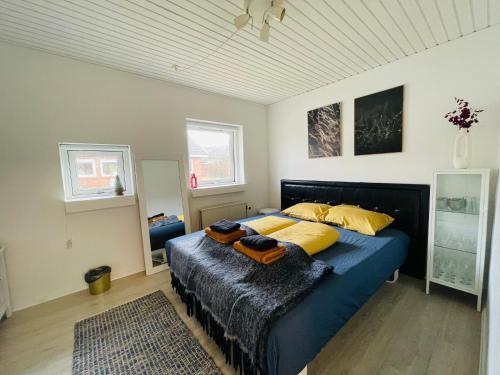 比伦德1 private room in Billund的一间卧室配有蓝色的床和黄色枕头