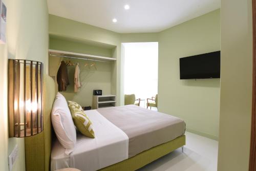 索伦托Sorrento Rooms Deluxe的一间卧室配有一张床和一台平面电视