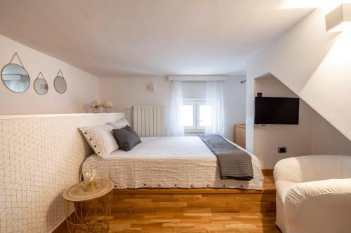 科拉托Cesarotti B&B的一间白色卧室,配有床和电视