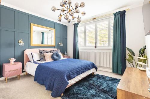 Streatham HillGorgeous House in Sidcup的一间卧室配有一张带蓝色墙壁和吊灯的床。
