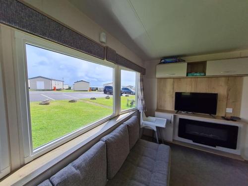 埃克斯茅斯3 Bedroom Deluxe Caravan at Haven Devon Cliffs的带沙发和大窗户的客厅