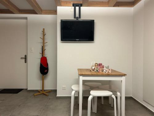 NetstalWohnung am Postweg的一间设有桌子的房间和墙上的电视