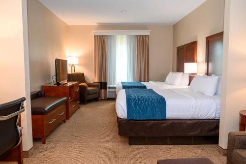 查尔斯顿Comfort Inn & Suites Patriots Point的配有一张床和一把椅子的酒店客房