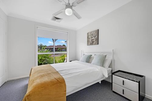 NarellanDiscover Mount Annan - Spacious 6-BR House的白色的卧室设有床和窗户