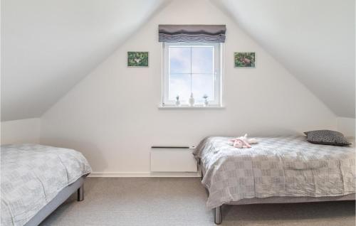 布罗3 Bedroom Beautiful Home In Brenderup Fyn的阁楼卧室设有两张床和窗户。