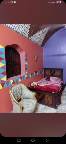 Najâ€˜ al MadÄbbNuba life Mostafa Guesthouse的一间卧室配有一张床和一把椅子