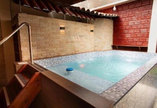伊基托斯Casa de Lujo 5 estrellas !的砖墙房间内的热水浴缸