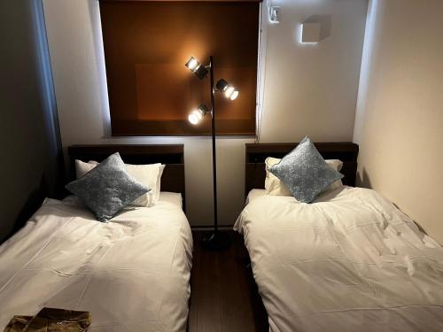 萩市360stay - Vacation STAY 18091v的一间设有两张床铺和枕头的客房