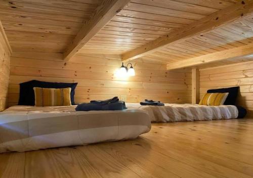 阿什伯勒Serene 1BR Cabin near NC Z00 with Loft & Waterview的木墙客房的两张床