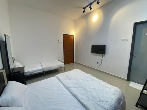 马六甲KSP Guest House的一间卧室设有两张床,墙上配有电视。