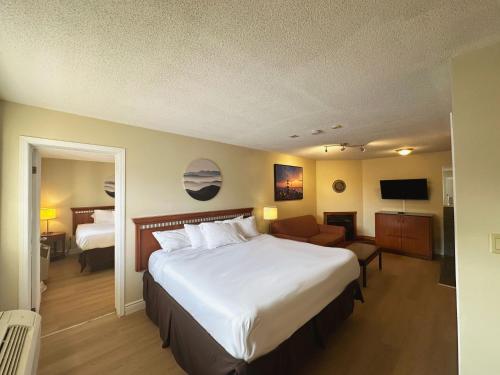 加纳诺克Riviera Inn And Suites 1000 Islands的酒店客房设有一张大床和一间客厅。