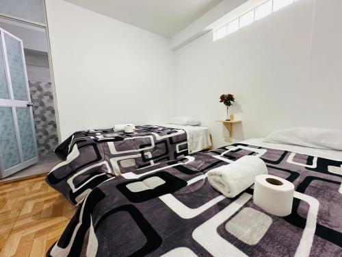 瓦拉斯Yerupaja Mountain Hostel的白色客房内的一张黑白床