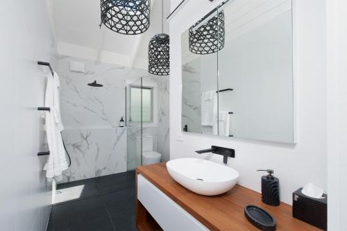 萨拉曼德湾Luxury Stay with Private Heated Pool in Salamander Bay的浴室配有白色水槽和淋浴。