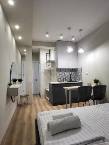 比托拉Good Times Luxury Apartments Bitola的厨房以及带床和桌子的客厅。