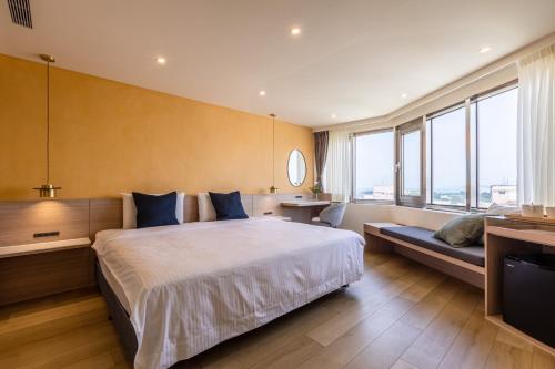 马公澎湖长春大饭店的一间卧室设有一张大床和一个大窗户