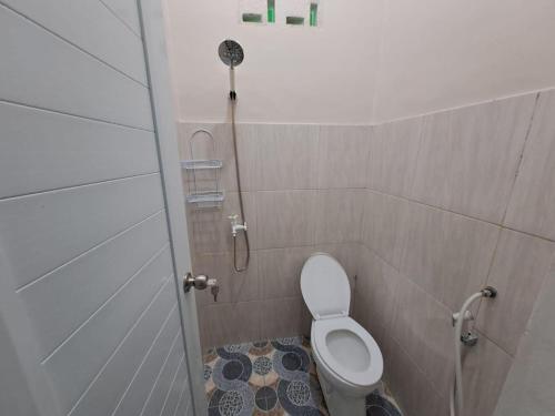 班达楠榜OYO 93695 Guest House Riharti Syariah的带淋浴和卫生间的浴室(位于隔间内)