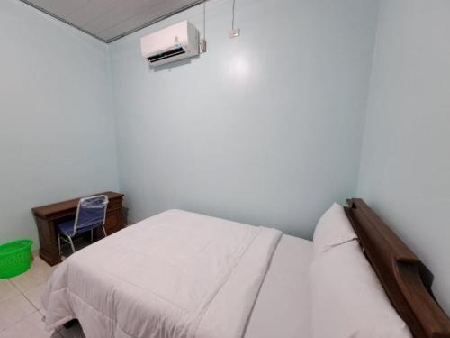 班达楠榜OYO 93695 Guest House Riharti Syariah的一间小卧室,配有一张床和一张书桌