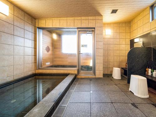 燕市APA Hotel Niigata Tsubame-Sanjo Ekimae的一间空浴室,有窗户和水箱