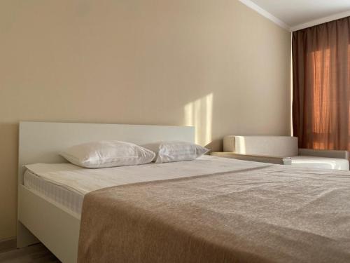 PrigorodnyyЖК Sati Club House的一间卧室配有一张带两个枕头的床