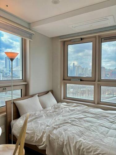 首尔Guil Property的一间卧室设有一张床和两个大窗户