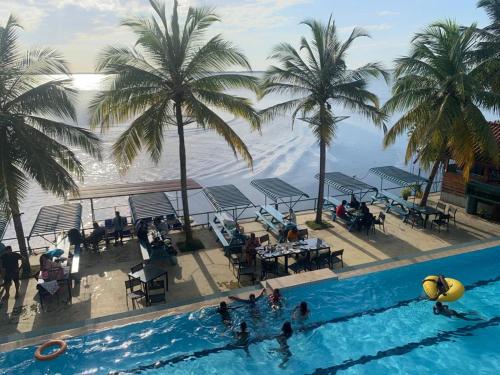卡图纳耶克New Saniro Lagoon Deck的享有棕榈树游泳池和大海的景色