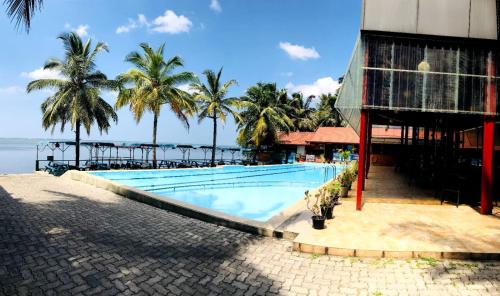 卡图纳耶克New Saniro Lagoon Deck的棕榈树建筑旁边的游泳池