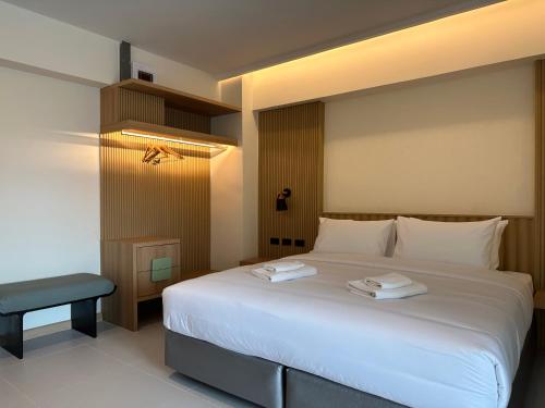 曼谷Jace hotel的卧室配有一张白色大床和一把椅子