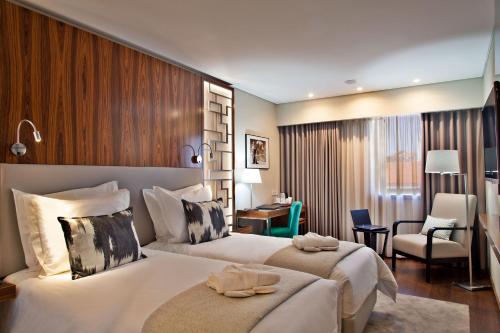 里斯本特里姆阿拉萨尔达尼亚酒店 的酒店客房设有一张大床和一张书桌。