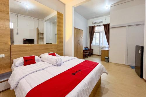 BlimbingRedDoorz Syariah @ Jl. Candi Kalasan的一间卧室配有一张带红色毯子的大床