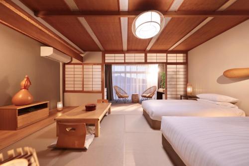 白滨阿卡利亚南新滨酒店的酒店客房设有两张床和一张桌子。