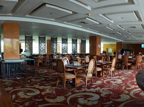 沙马林达Five Premiere Hotel的用餐室设有桌椅和窗户。
