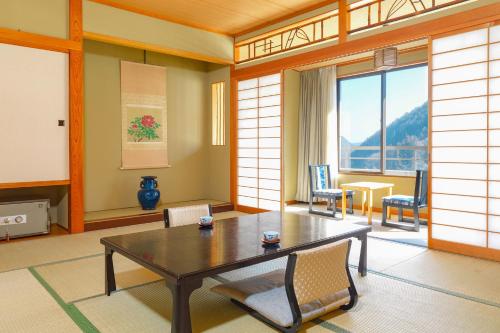 上田市Ooedo Onsen Monogatari Kakeyu的客房设有桌椅和大窗户。