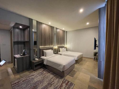 巨港Salatin Hotel Palembang的酒店客房设有两张床和电视。