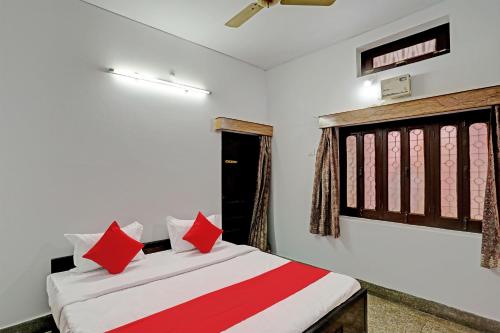 瓦拉纳西Super OYO Flagship Shivansh Paying Guest House的一间卧室配有红色枕头的床