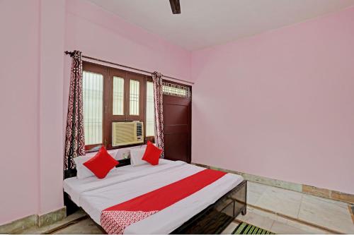 瓦拉纳西Super OYO Flagship Shivansh Paying Guest House的一间卧室配有红色枕头的床