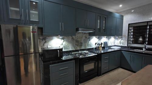 黑角Résidence Honorine的厨房配有蓝色橱柜和炉灶烤箱。