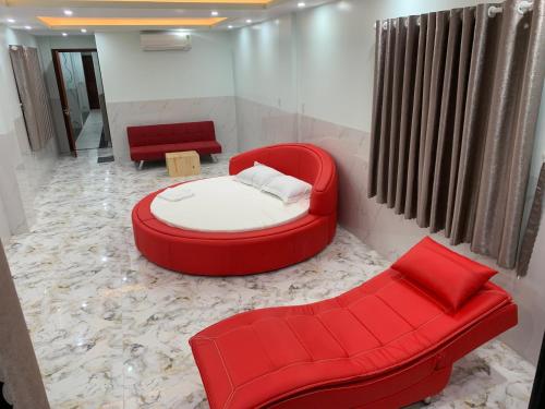 Ấp Ðông An (1)Bờ Hồ Hotel的一间设有红色床和两张红色椅子的房间