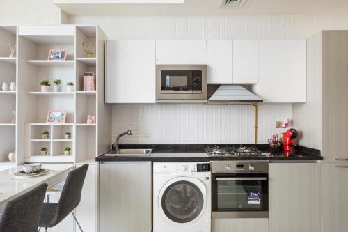 迪拜Modern Studio in Arjan-Dubailand的厨房配有洗衣机和微波炉。