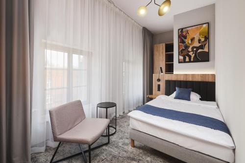 什切青Halo Szczecin的卧室配有床、椅子和窗户。