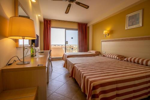 滨海罗克塔斯ALEGRIA Fenix Family的酒店客房配有两张床和一张书桌